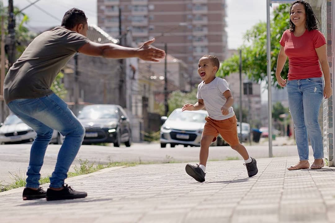 A child running to his father from his mother before day's out.